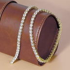 Gold and silver bracelet on a brown leather surface