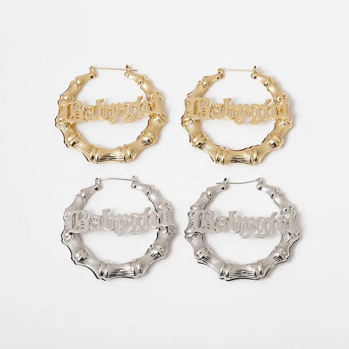Four pairs of hoop earrings in gold and silver on a white background