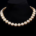 Gold necklace with clear stones on a black background