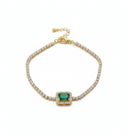 Gold bracelet with a green gemstone on a white background