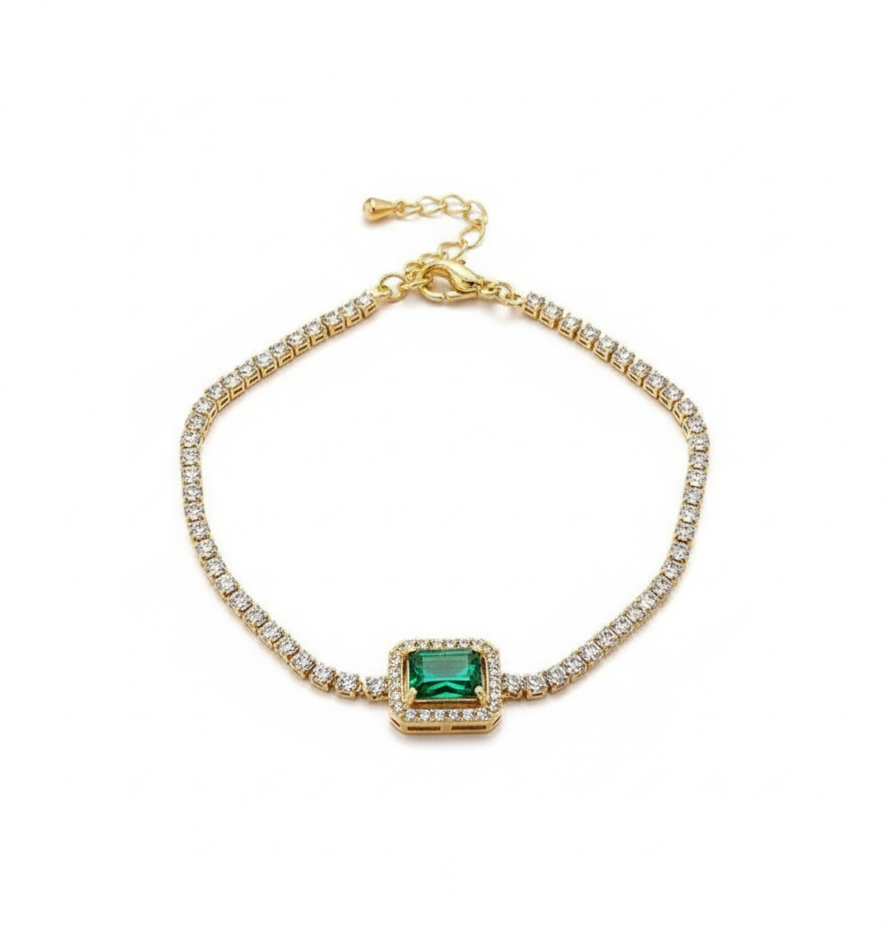 Gold bracelet with a green gemstone on a white background