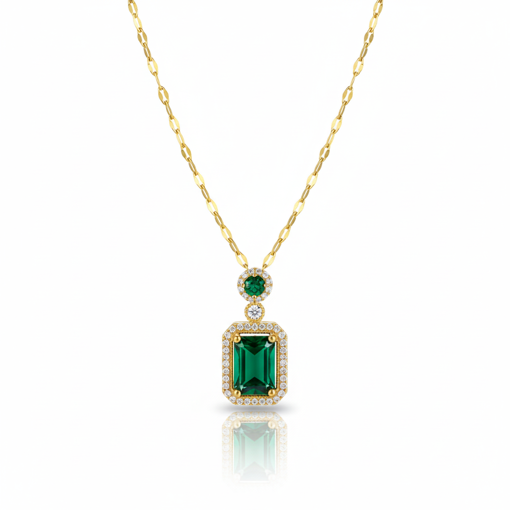 Gold necklace with a green gemstone pendant on a white background