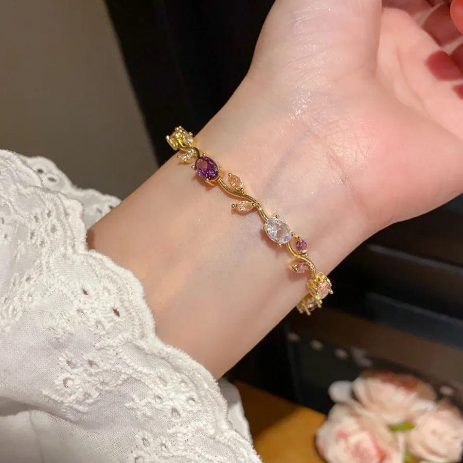 Gold bracelet with gemstones on a wrist, blurred background