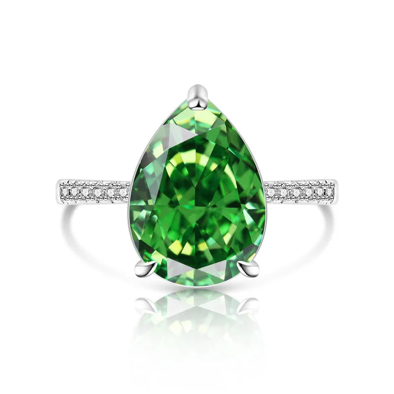 Green teardrop gemstone ring with silver band on a white background