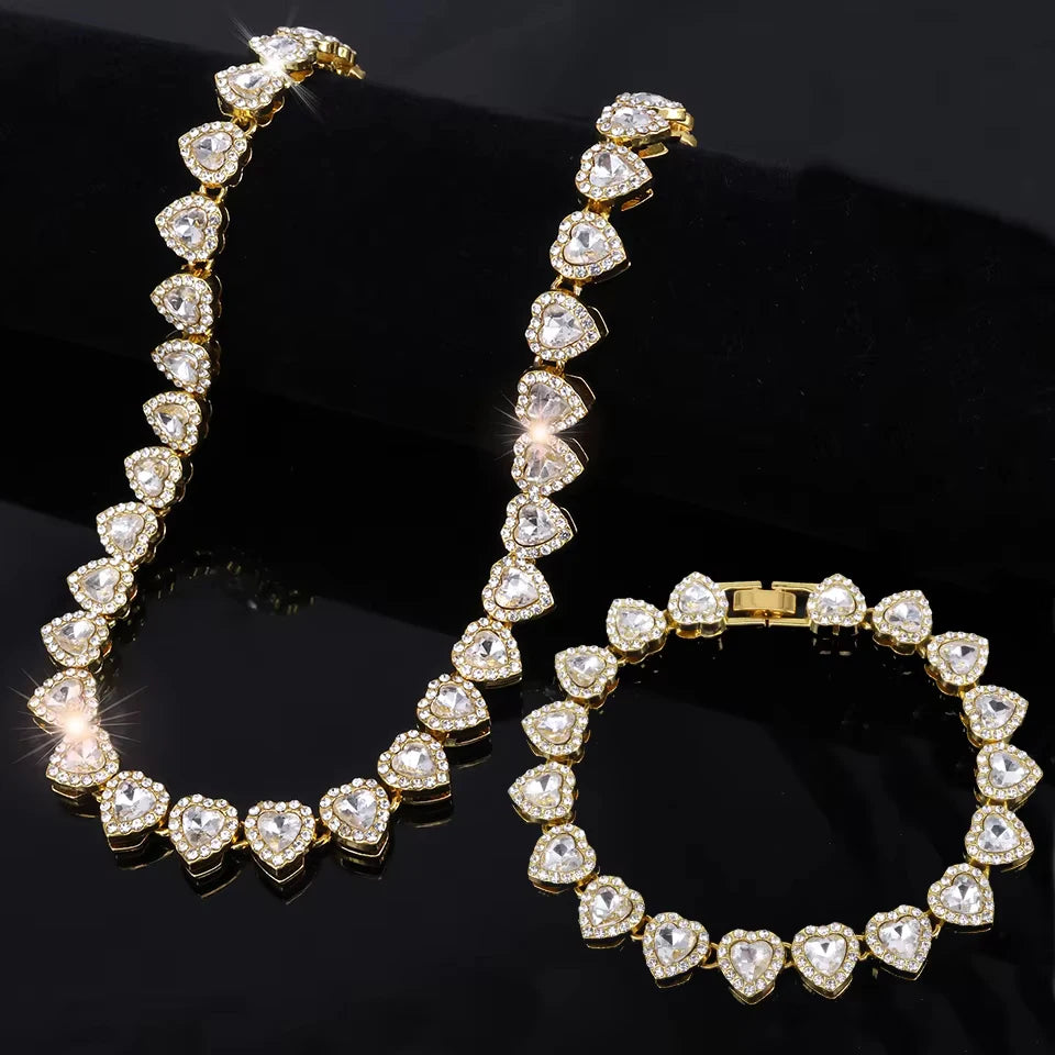 Gold necklace and bracelet set with heart-shaped diamonds on a black background