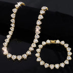 Gold necklace and bracelet set with heart-shaped diamonds on a black background