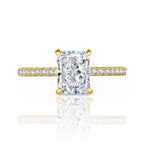 Gold ring with a large diamond and smaller diamonds on the band against a white background