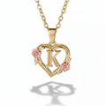 Gold necklace with a heart-shaped pendant featuring the letter 'K' and pink flowers on a white background.