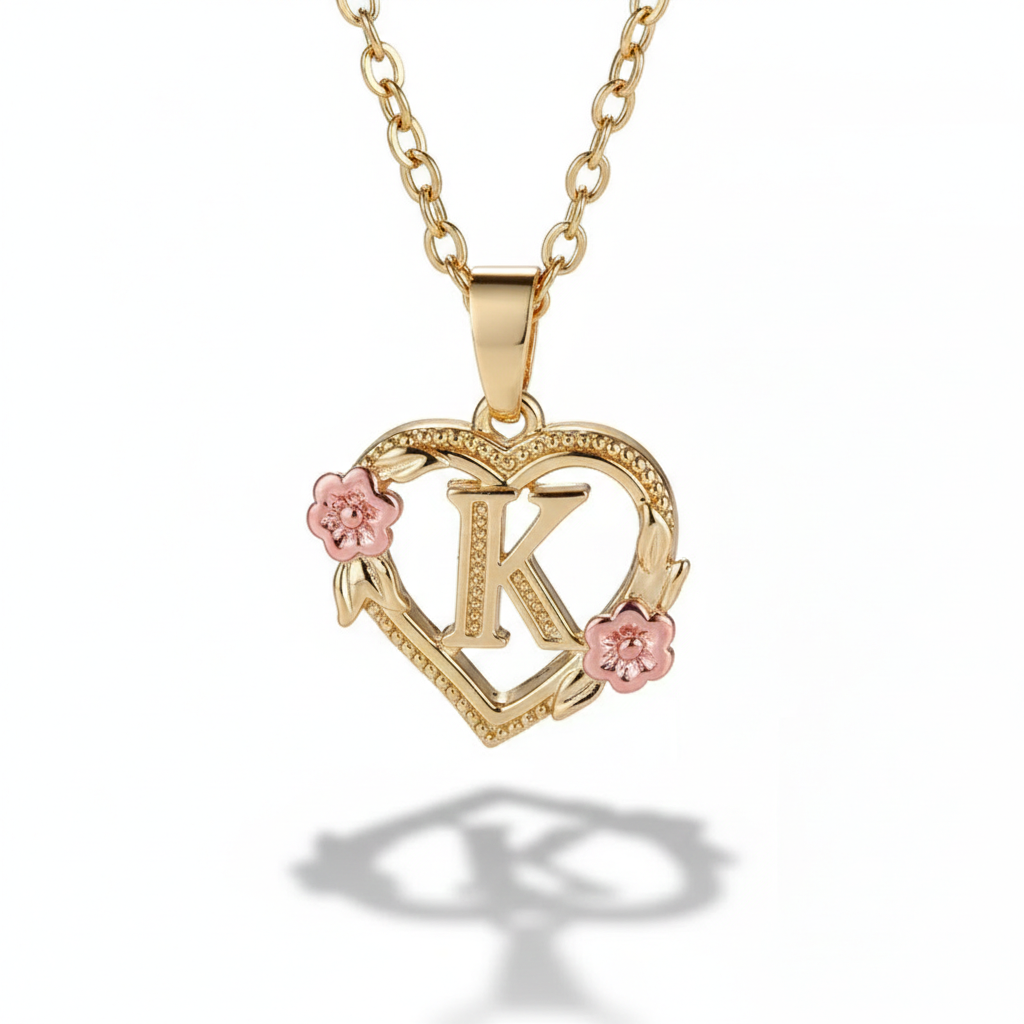 Gold necklace with a heart-shaped pendant featuring the letter 'K' and pink flowers on a white background.