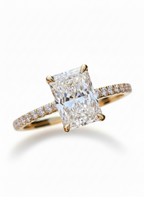 Diamond ring with a large central gemstone and smaller stones on the band against a white background