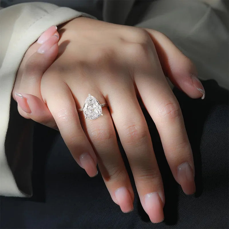 Close-up of a hand wearing a diamond ring on a dark background