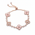 Rose gold bracelet with pink floral charms on a white background