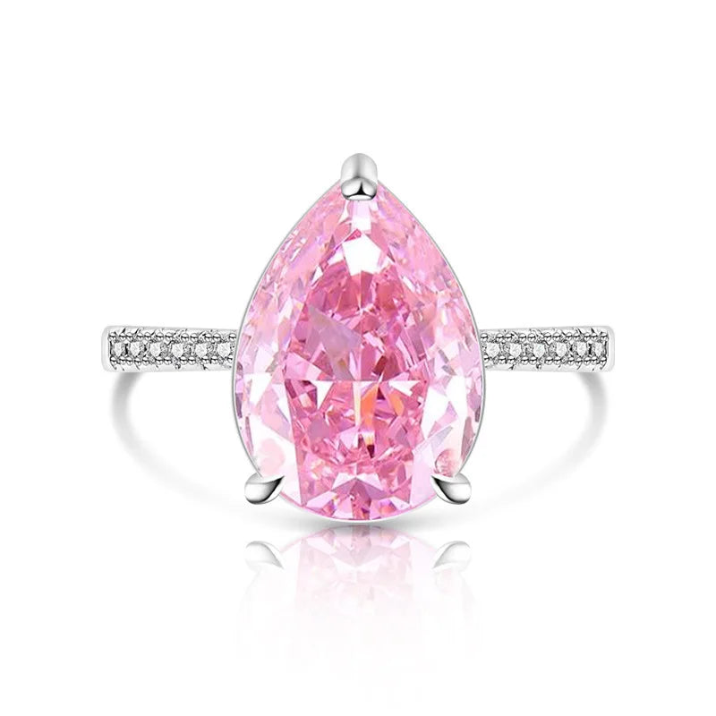 Pink teardrop-shaped diamond ring with a white gold band on a white background