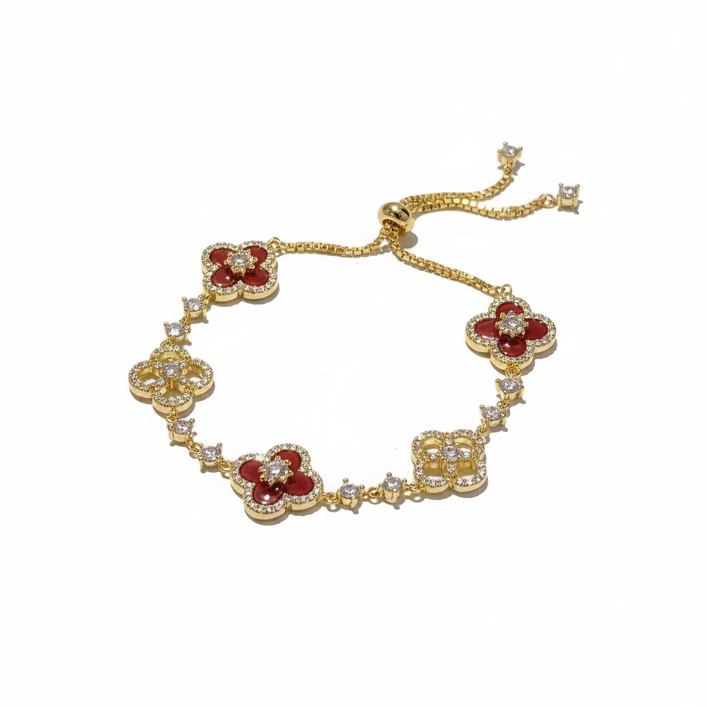 Gold necklace with red floral pendants and clear stones on a white background