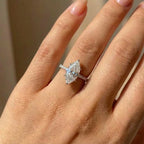 Diamond ring on a person's finger with a neutral background