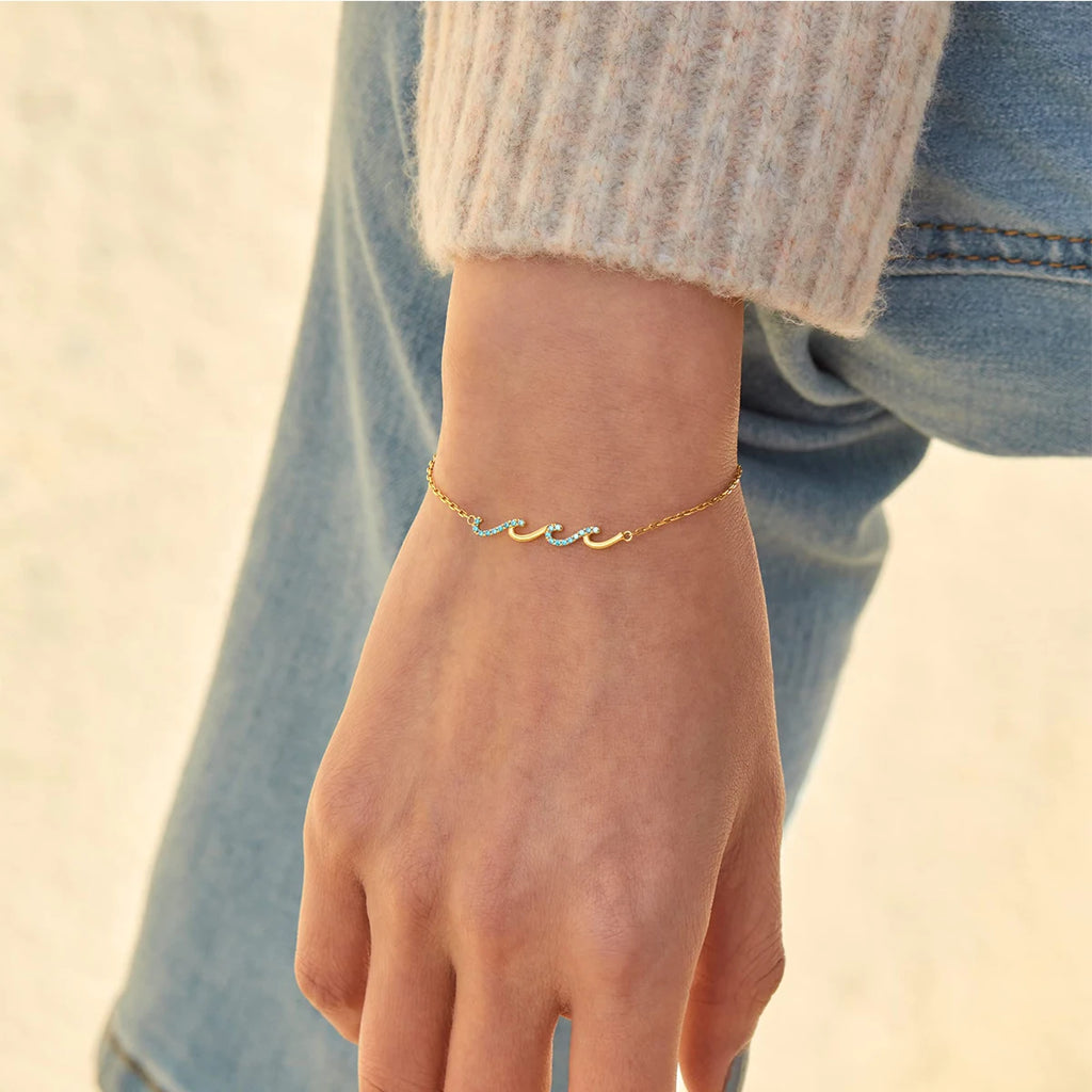 Gold bracelet on a wrist with a blurred background