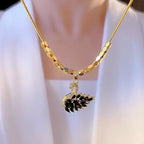 Gold necklace with a black swan pendant on a white background
