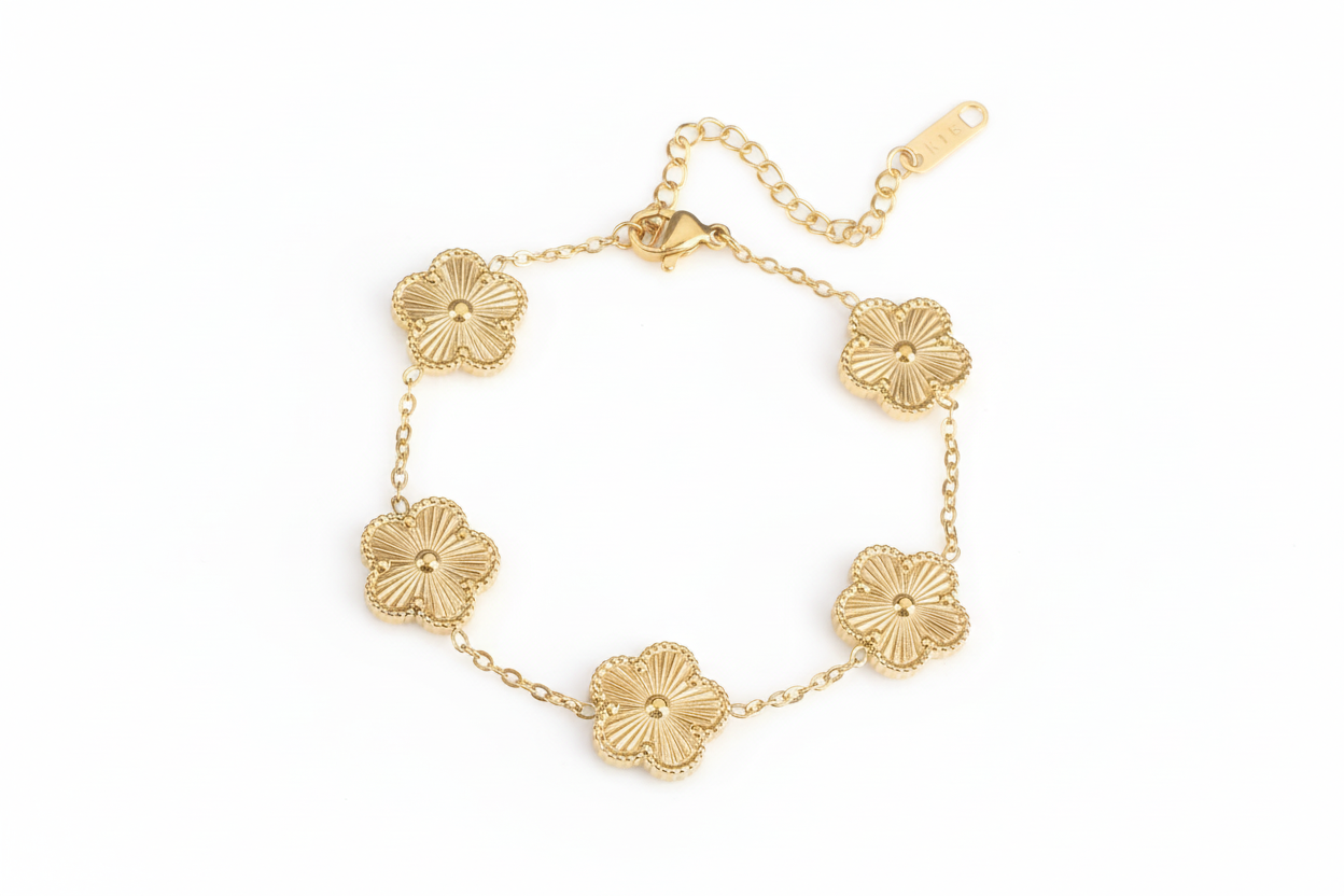 Gold bracelet with floral designs on a white background