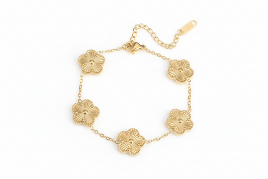 Gold bracelet with floral designs on a white background