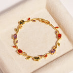 Gold bracelet with multicolored gemstones on a beige surface