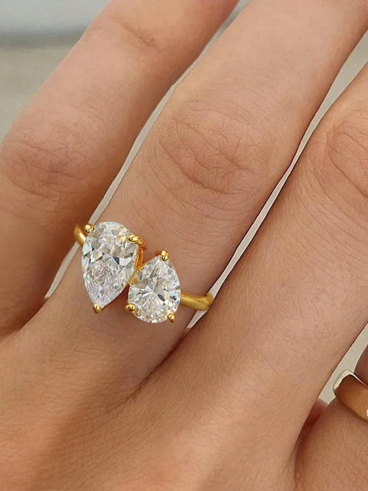 Gold ring with two pear-shaped diamonds on a hand