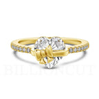Gold ring with heart-shaped diamond and bow design on a white background