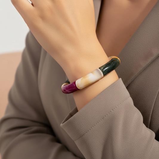 Person wearing a colorful bracelet on a neutral background