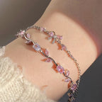 Bracelet with pink gemstones on a wrist against a neutral background